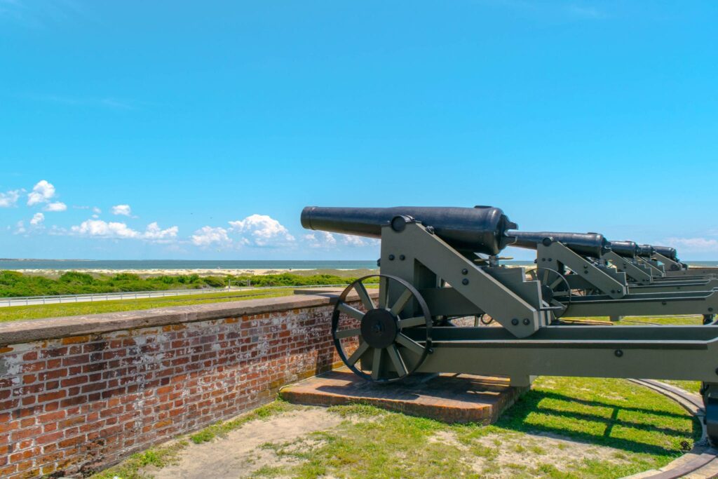 cannons at fort macon state park with ocean visible in the distance. fort macon is one of the best things to see in atlantic beach nc
