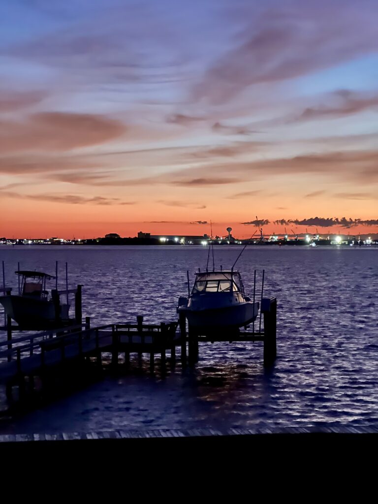 view of sunrise over bogue sound with a docked boat in the foreground, one of the coolest things to see in atlantic beach nc